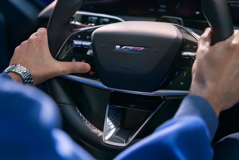 Close-up of a Man About to Press the V-Button on the 2026 OPTIQ-V Steering Wheel | Mildenberger Motors in Hamilton Montana MT