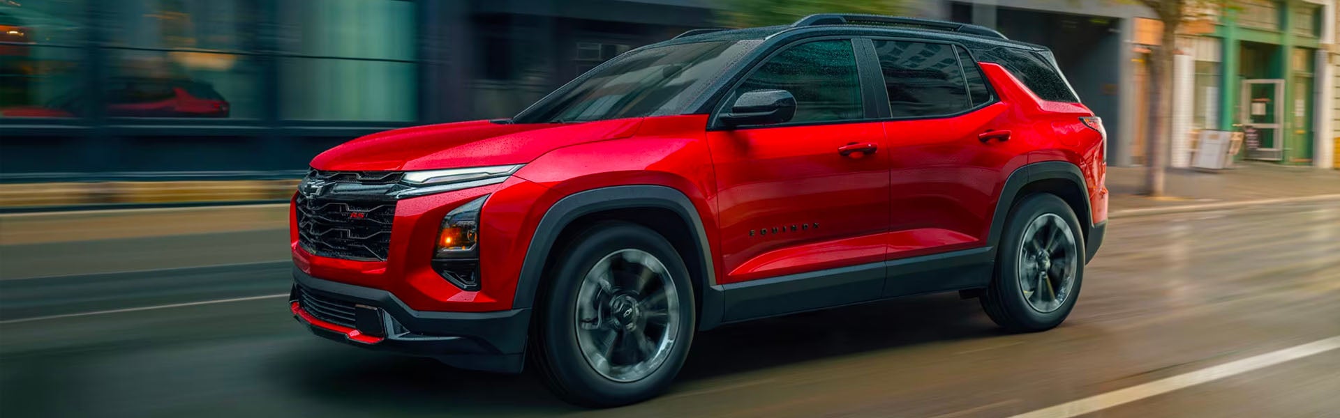 Red Chevrolet Equinox driving through the city