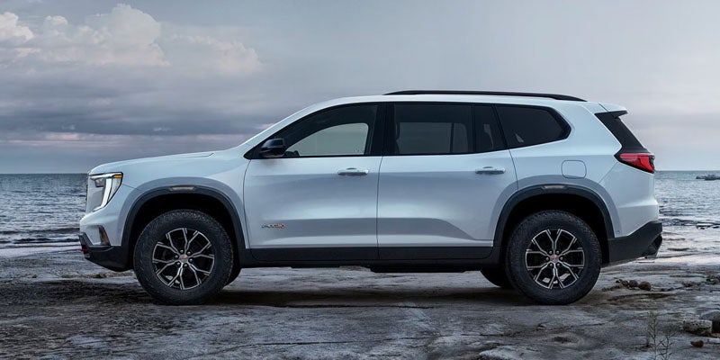 GMC SUV parked near the water under cloudy skies